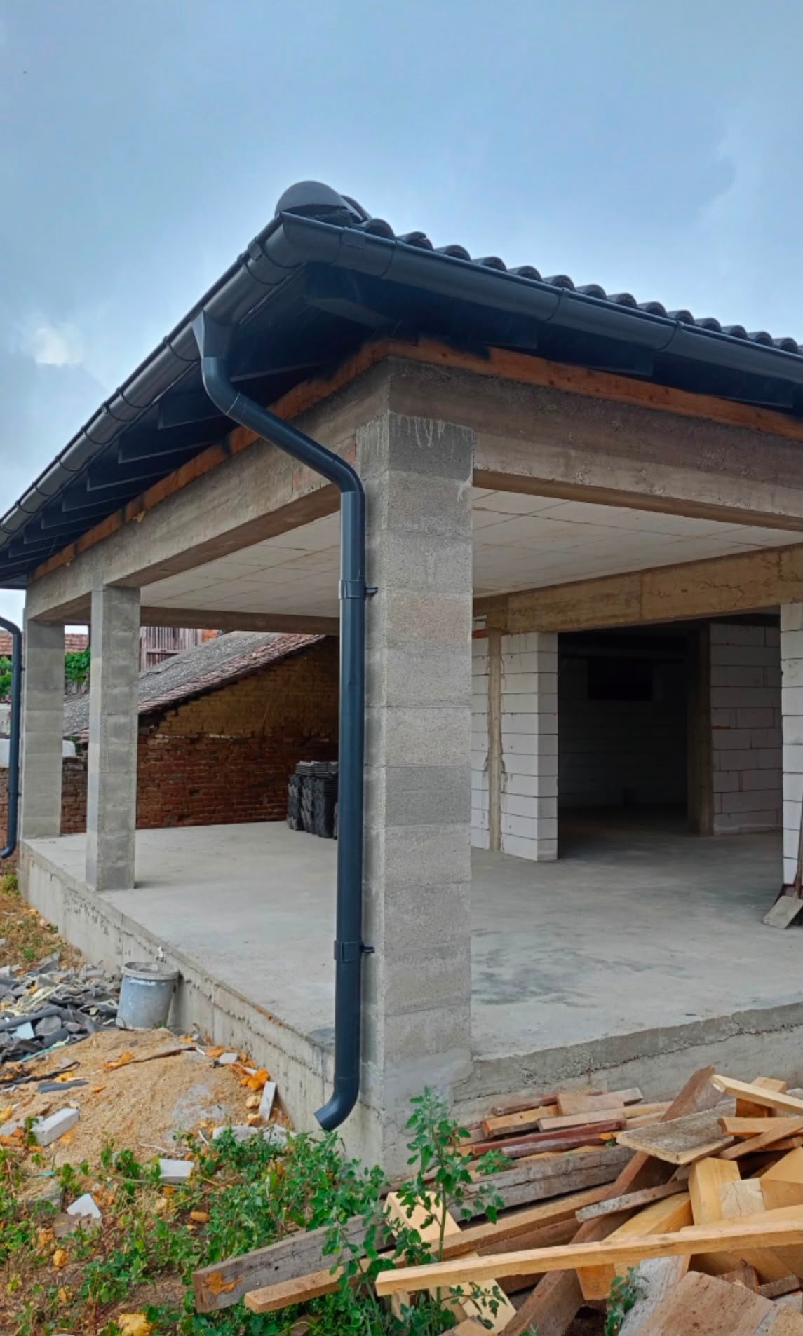 Casă în construcție cu acoperiș montat și terasă acoperită